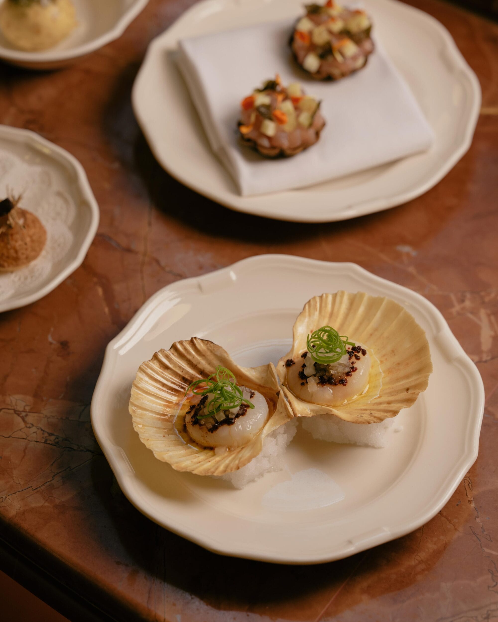 finely plated seared scallops served at Reine & La Rue