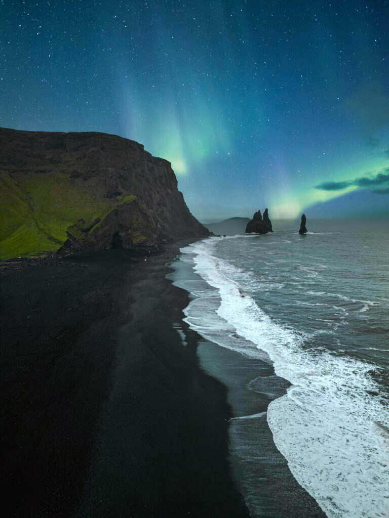 Northern lights over the black sand beach Reynisfjara in Iceland