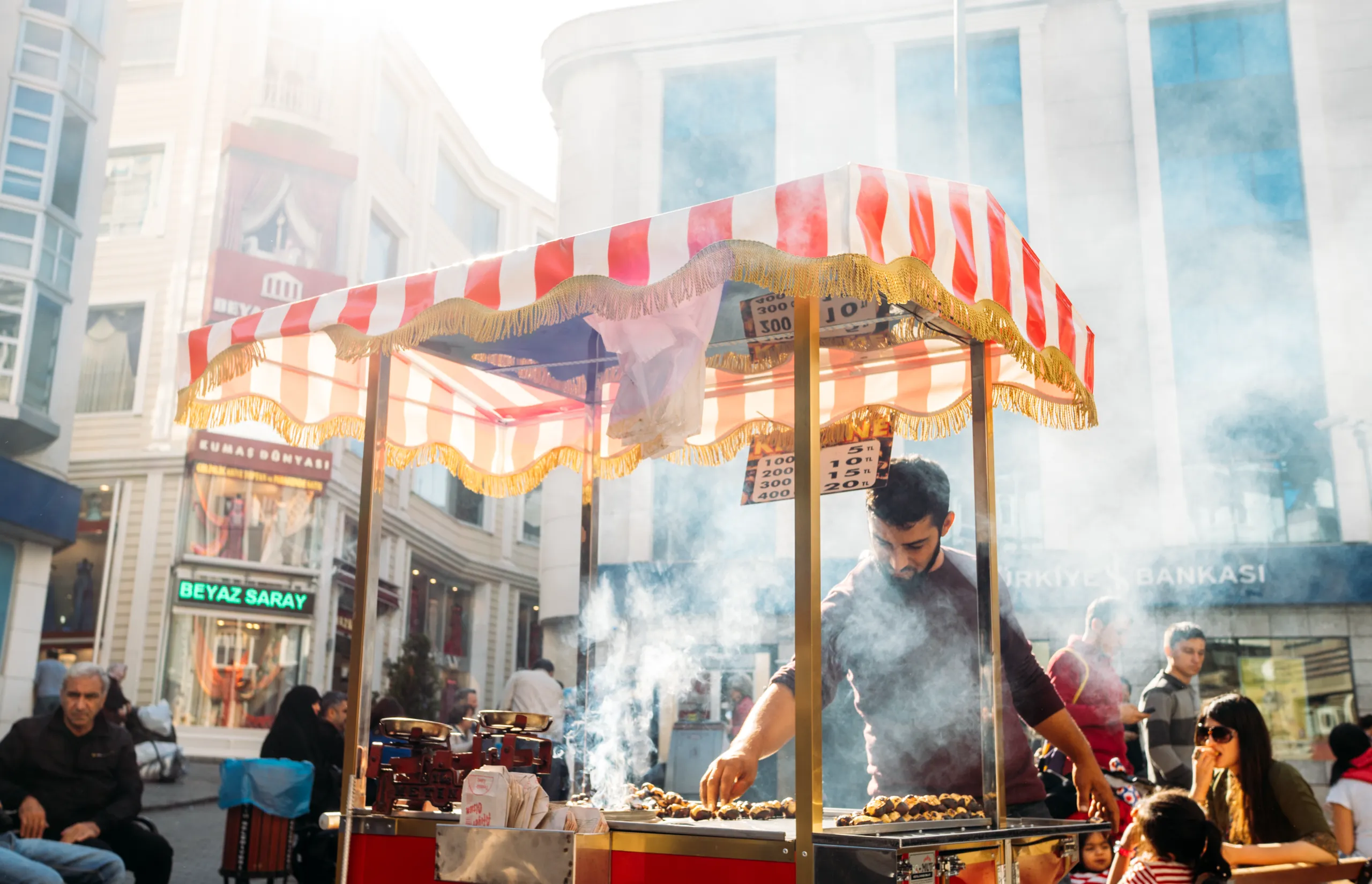 Istanbul, Turkey - October 25, 2014: Chestnut roasting chestnuts a customer. Roasted chestnut is a popular street food in Istanbul, enjoyed both by locals and tourists.