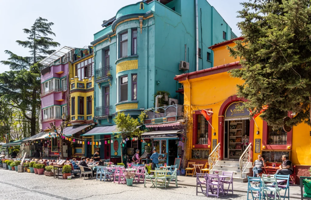Tourists enjoying a sunny afternoon, sitting outside cafes and restaurants in this colorful street in the Sultanahmet district, Istanbul, Turkey