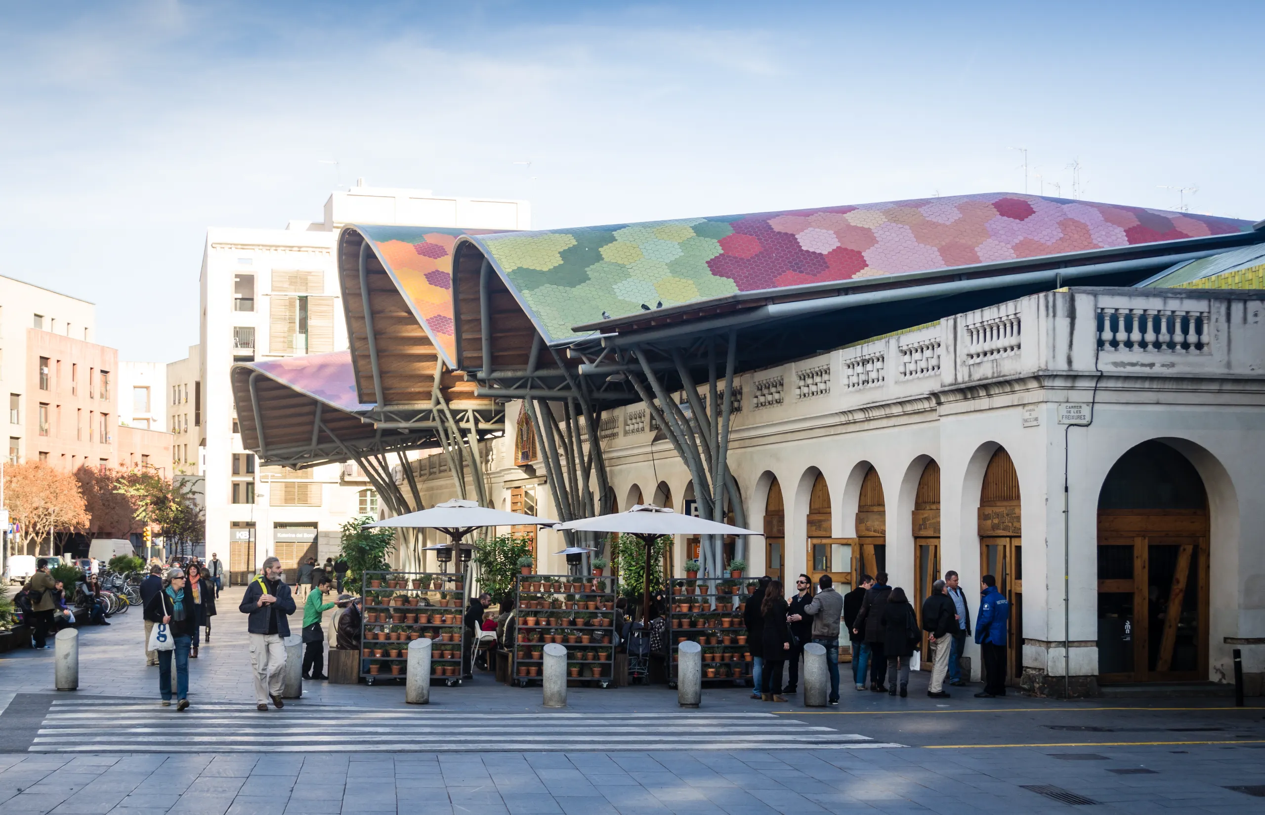 Grand Tour of Catalonia | Barcelona, Spain - December 30, 2012: People walking and talking near Santa Caterina market in Barcelona, Spain. Sunny day.