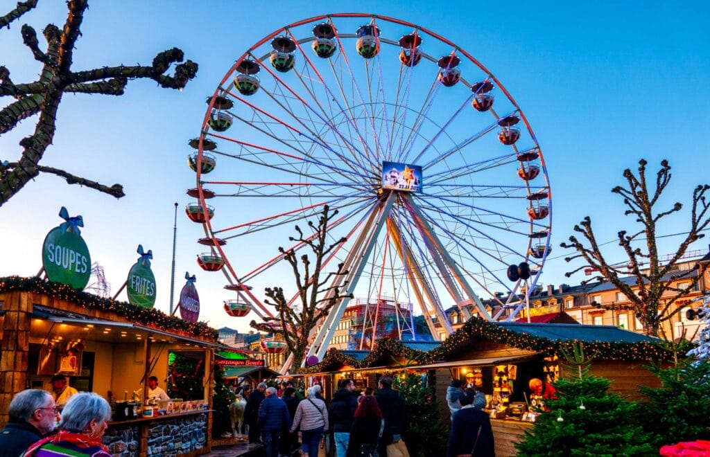 The vibrant Ferris wheel at the Wantermaart (Winter Market) in Luxembourg City, Luxembourg, surrounded by festive stalls and visitors.