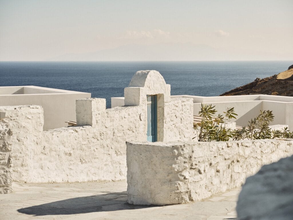 Whitewashed Cycladic architecture at Four Seasons Hotel Mykonos with blue door and sea views