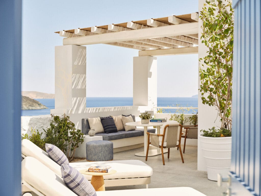 Suite outdoor terrace at Four Seasons Hotel Mykonos with pergola, daybed, dining table and sweeping ocean views