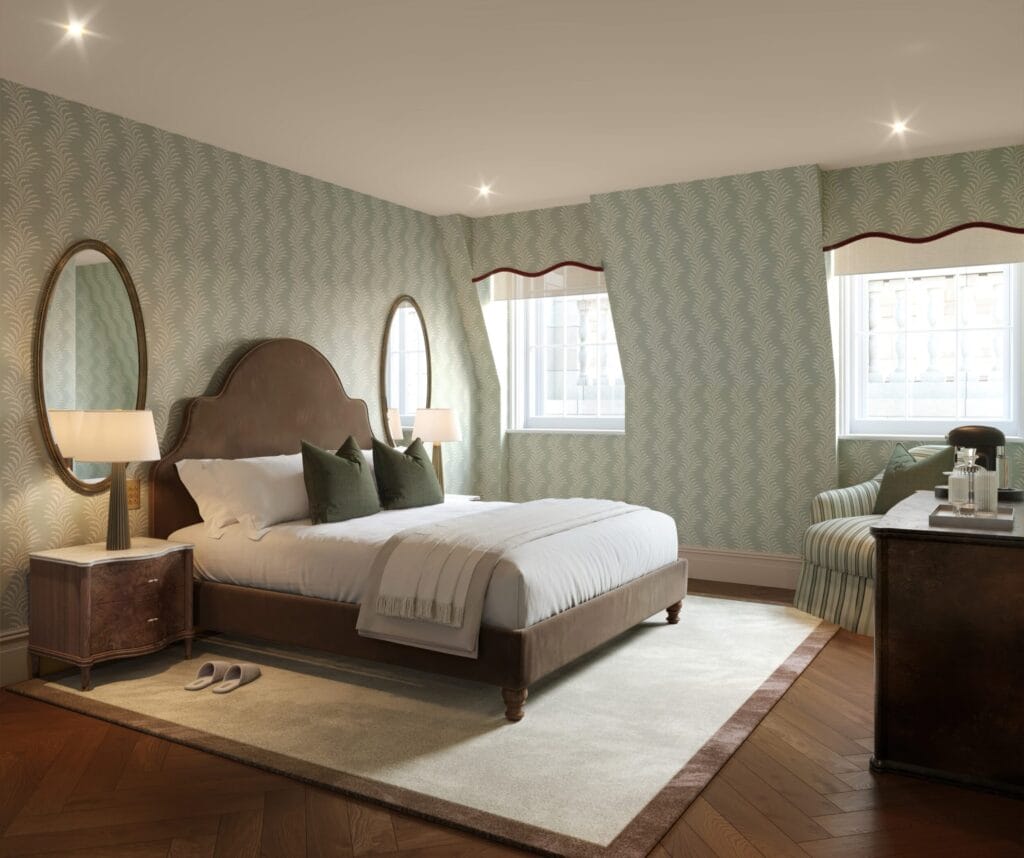 A mansard bedroom at Waldorf Astoria London Admiralty Arch with sloped ceilings, sage botanical wallpaper and dormer windows