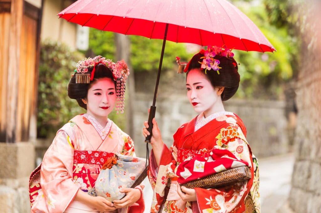 Maiko or geiko apprentices, holding a red paper umbrella