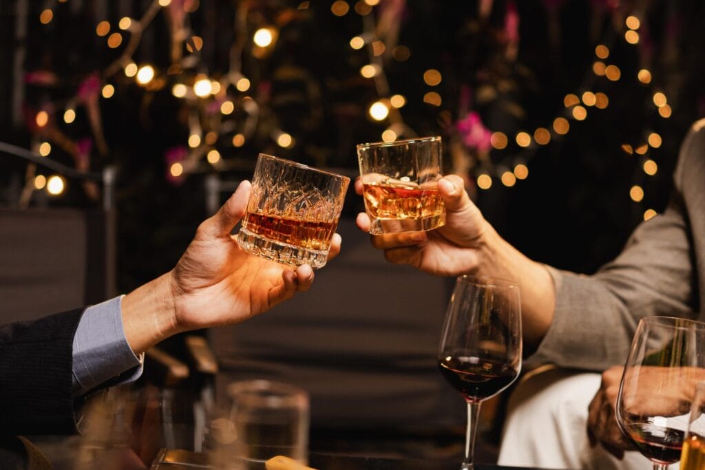 A festive toast - glasses filled with amber whiskey