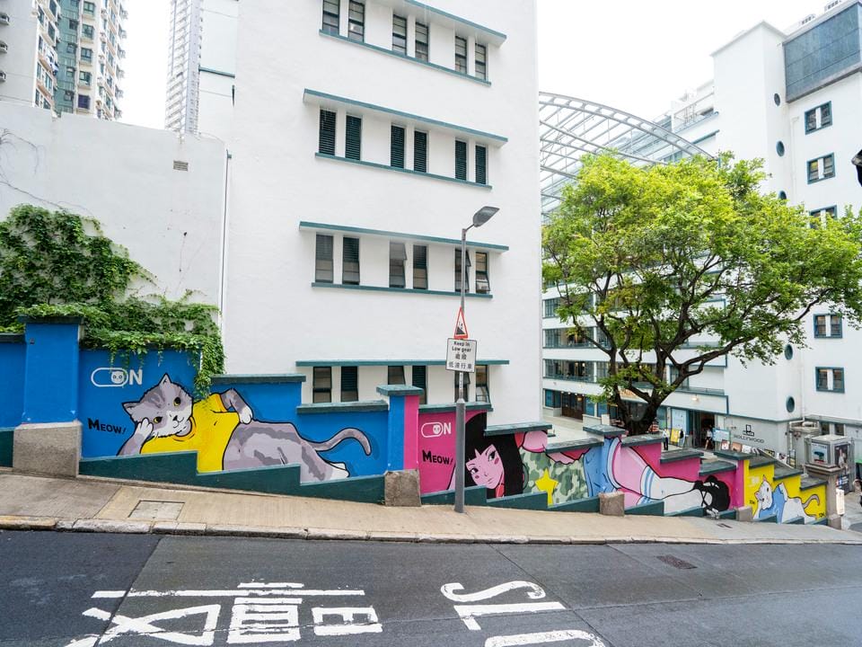 Sreet art mural titled "Chill Mode On" by artist Tom Tsang, located on a staircase wall in Hong Kong as part of the HKwalls Street Art Festival