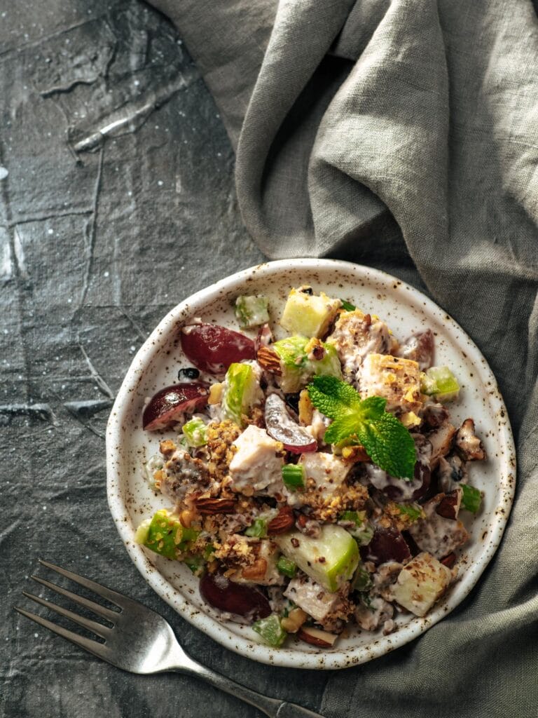Waldorf salad served on a speckled white plate