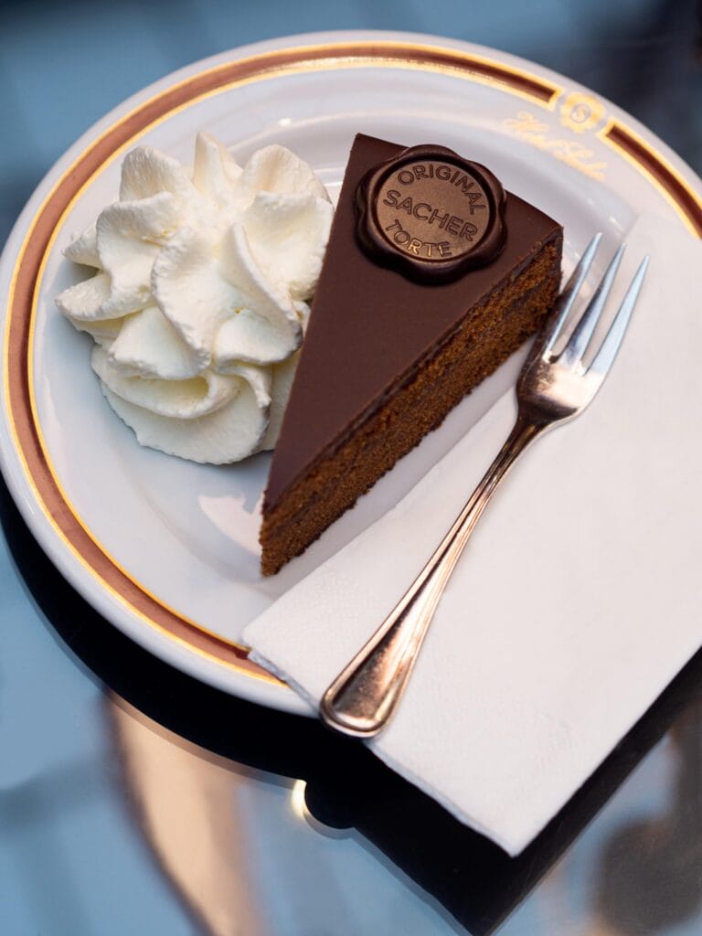 A slice of Original Sacher-Torte served with whipped cream