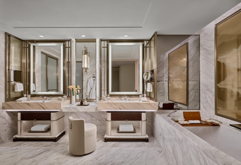Freshen up at the double vanities clad with hand-selected marble