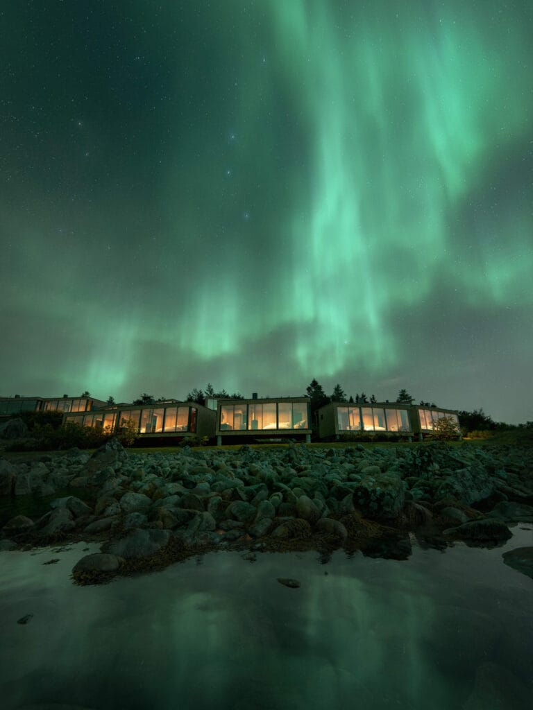 Render of the Norrøna Lodge at Andørja with the northern lights above the Norwegian fjords