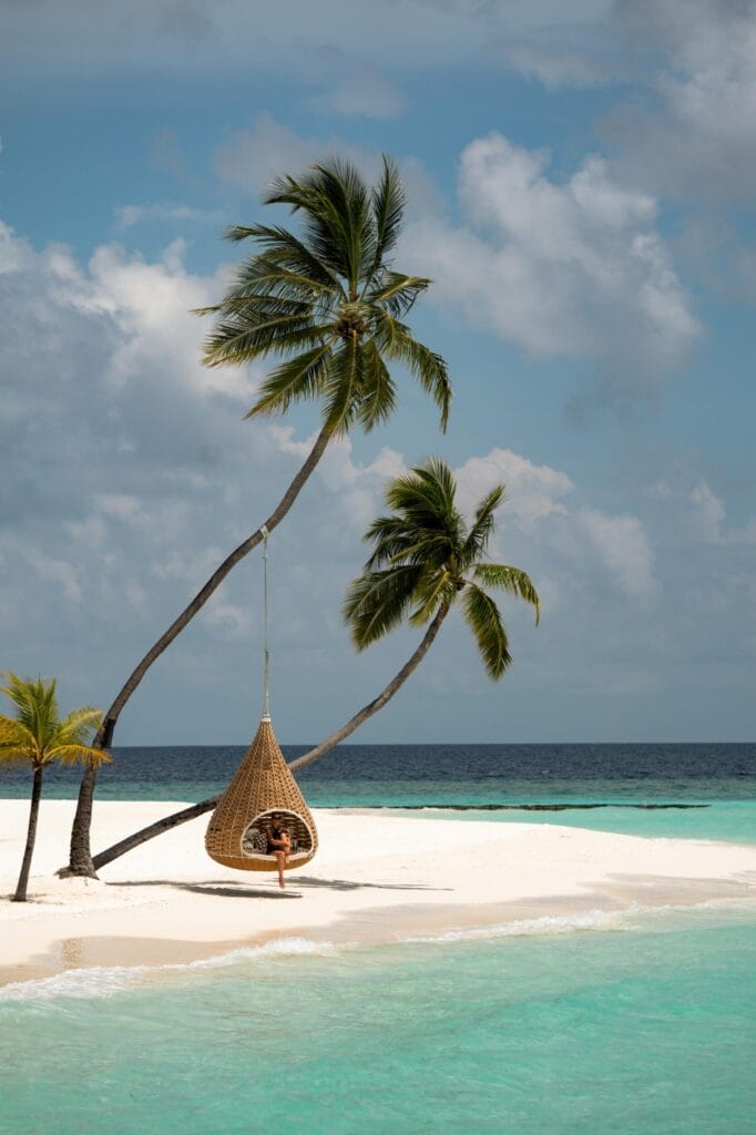 Iconic hanging birdcage swing on the white-sand beach at Constance Halaveli