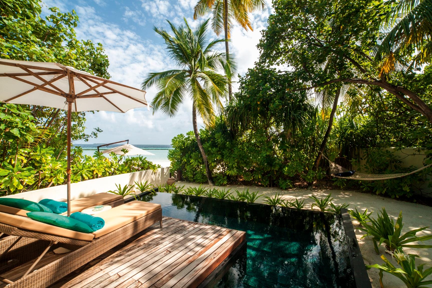 A a private pool and sun loungers at a beach villa