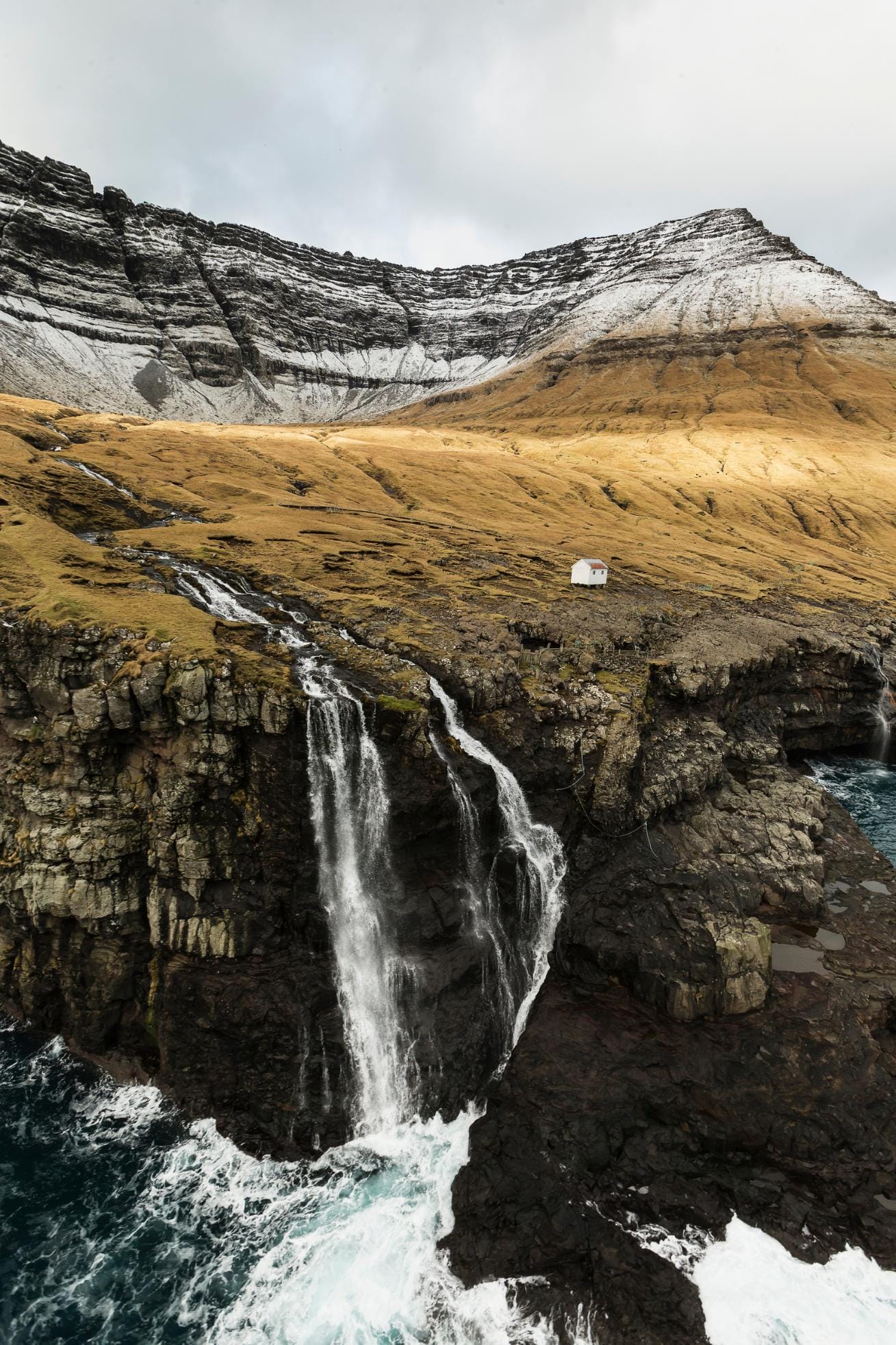 A multi-tiered waterfall cascading down dark basalt cliffs